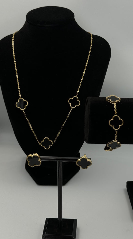 Mizori Jewelry black and gold stainless steel clover earrings displayed on a jewelry stand, elegant minimalist design, women’s fashion accessory.