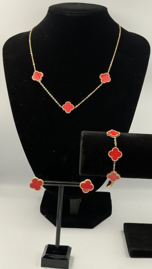 Mizori Jewelry red and gold stainless steel clover jewelry set on stand, including bracelet, necklace, and earrings, elegant minimalist design.