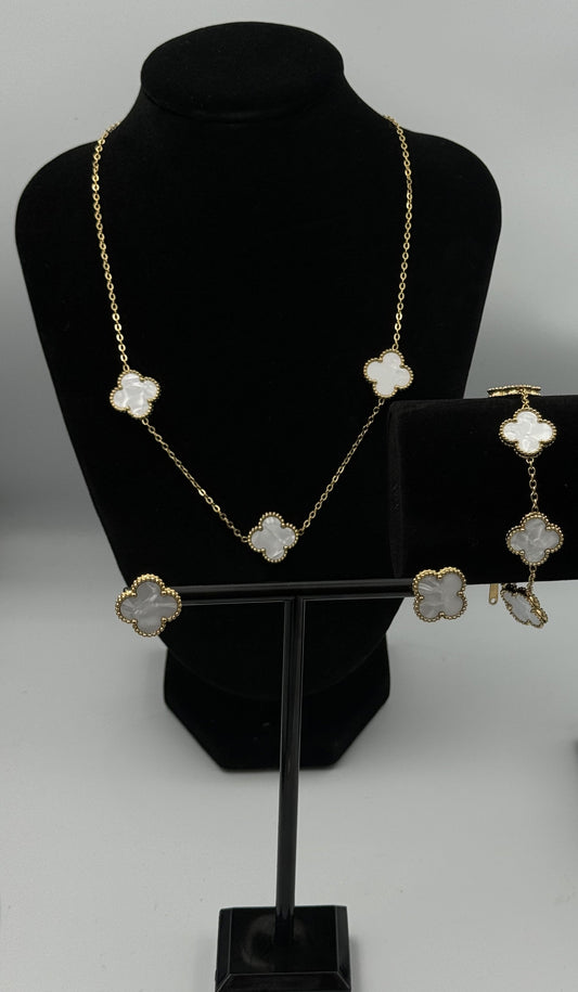 “Mizori Jewelry white and gold stainless steel clover jewelry set on stand, including bracelet, necklace, and earrings, elegant minimalist design
