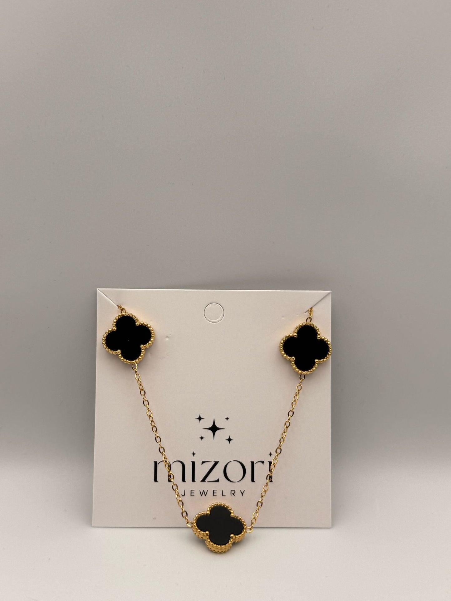 Mizori Jewelry black and gold stainless steel clover necklace, elegant minimalist women’s fashion accessory.