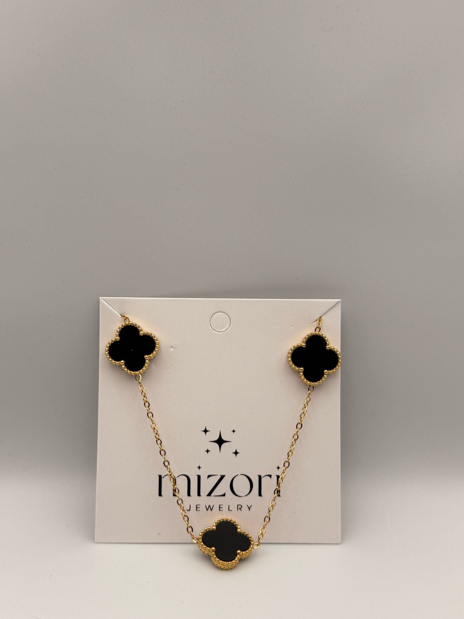 Mizori Jewelry black and gold stainless steel clover necklace, elegant minimalist women’s fashion accessory.